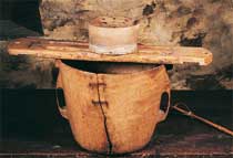 Abatza, recipiente  en madera de abedul, utilizado para contener y calentar  la leche de oveja con la que se elabora el queso. Sobre ella esta colocada una tabla sobre la que se apoya el molde para el queso, pudiendo escurrir así el suero